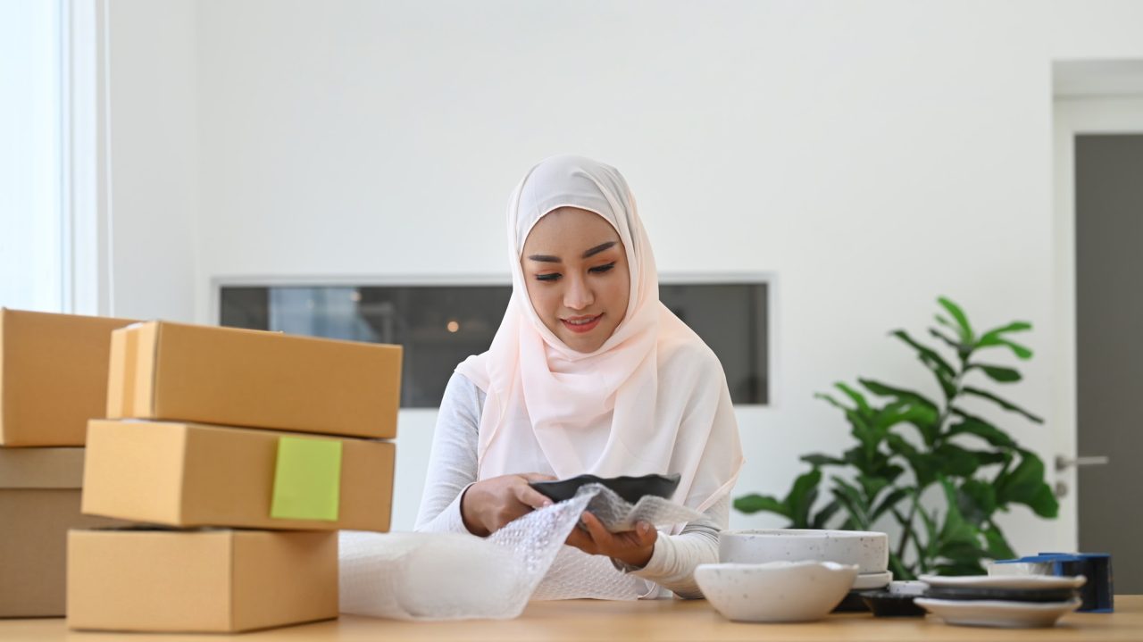 muslim-woman-business-owner-packing-product-preparing-parcel-for-shipping-to-costumer-.jpg